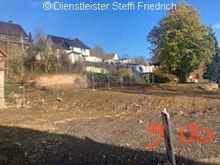 Blick auf freigelegtes Grundstück, im Hintergrund Bauzaun und Häuserzeile