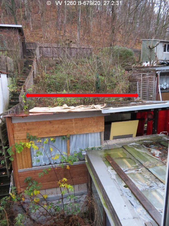 Blick aus dem Wohnhaus in den hinteren Grundstücksbereich, hangansteigend, umzäunt, im Vordergrund Anbauten im schlechten Zustand