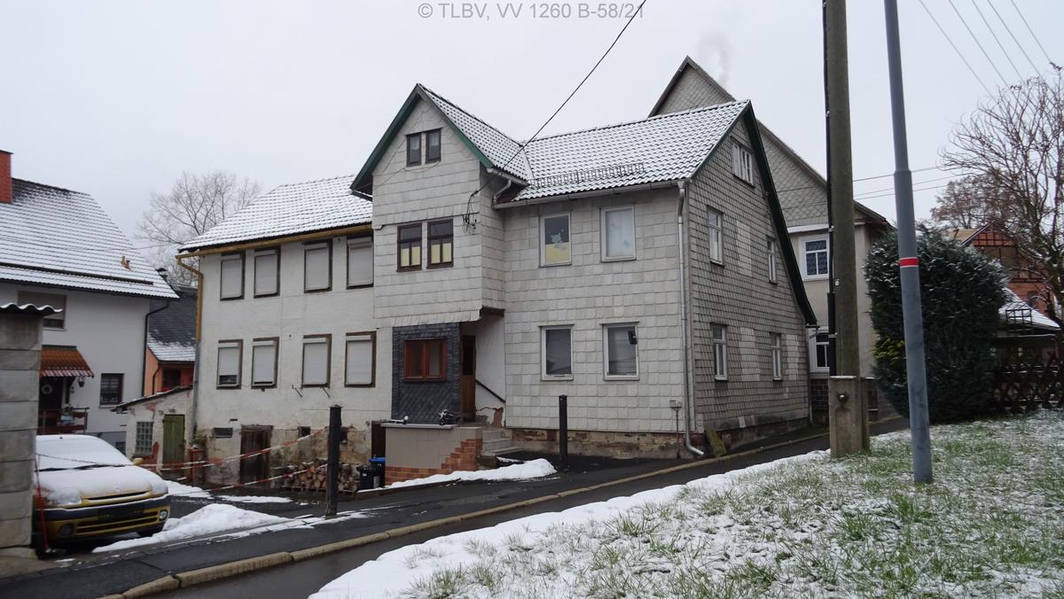 giebelständiges, freistehendes Zweifamilienhaus, Fassade aus Asbestschieferplatten hell, Satteldach mit einem Mix aus Tonziegeln und Betondachsteinen