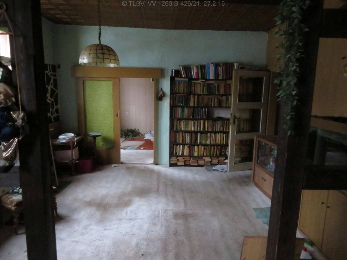 Zimmer mit Fachwerkbalken; zwei Türen, eine davon als breite Schiebetür; unberäumt; renovierungsbedürftig