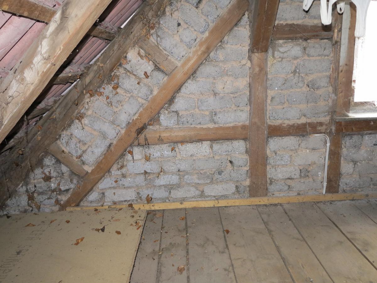 Blick im Dachboden auf Giebel; Holzfachwerk ausgemauert; keine Dämmung