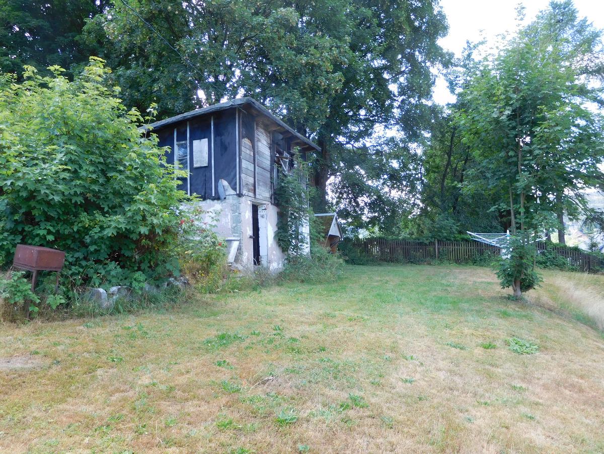 Wiesenfläche mit Gebüsch und Schuppen
