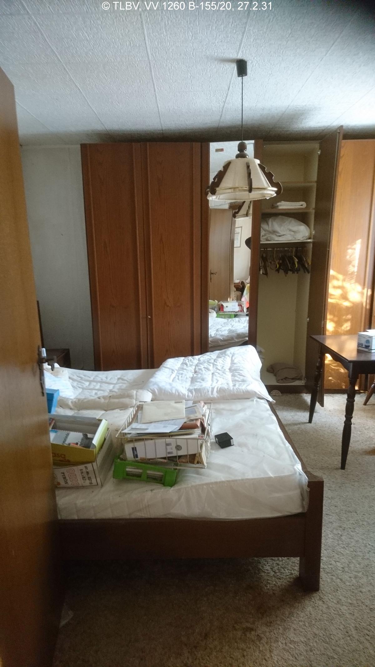Blick in Schlafzimmer, unberäumt, textile Auslegware, Deckenplatten aus Styropor