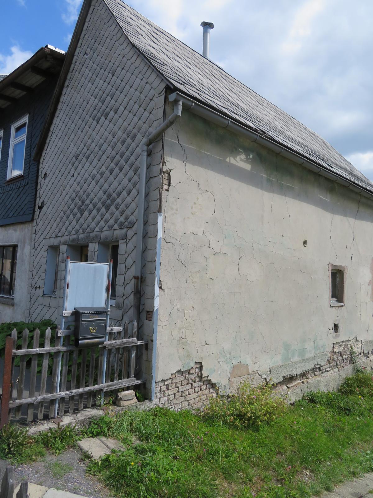 Nebengebäude mit wenig Fenstern, Fassade sehr schadhaft