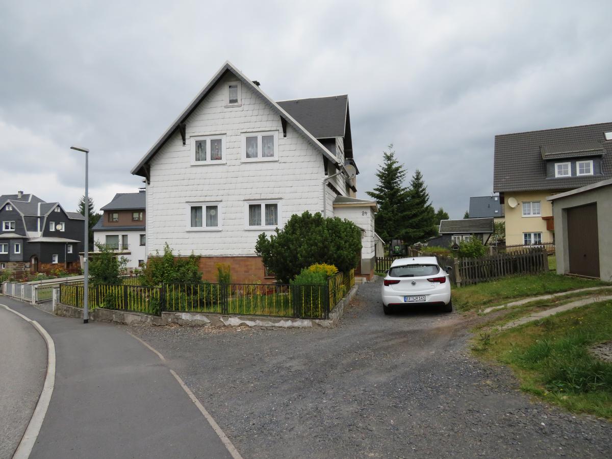 Giebelseite (Front) mit Vorgarten, gekieste Zufahrt