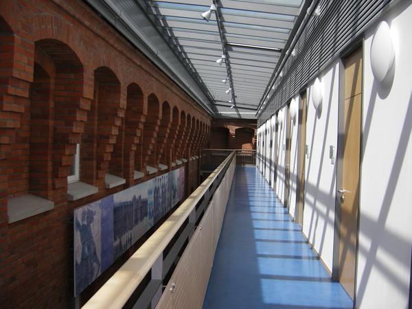 Laubengang mit Glasdach überdacht, linksseitig Lichthof zu Altbau