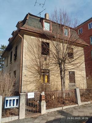 Straßenansicht eines zweigeschossigen Wohnhauses mit Vorgarten