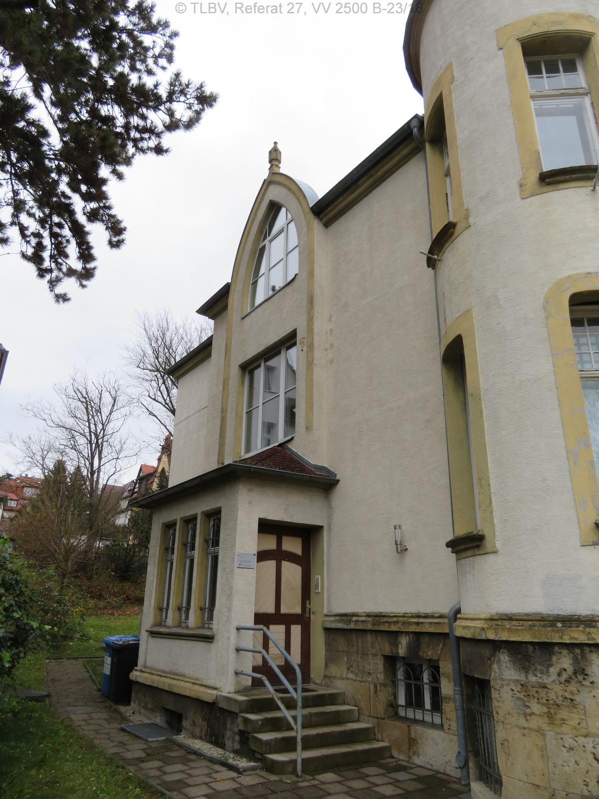 Hauseingangsbereich mit massivem Windfang; Treppenfenster im OG kirchenfensterförmig