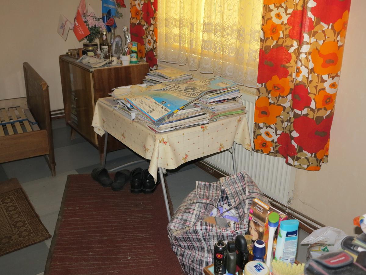 Blick in ehem. Schlafzimmer; unberäumt, z.T. vermüllt; Einrichtungsgegesntände, Tapeten und Fußboden verschlissen; 1 Fenster und 1 Heizkörper vorhanden