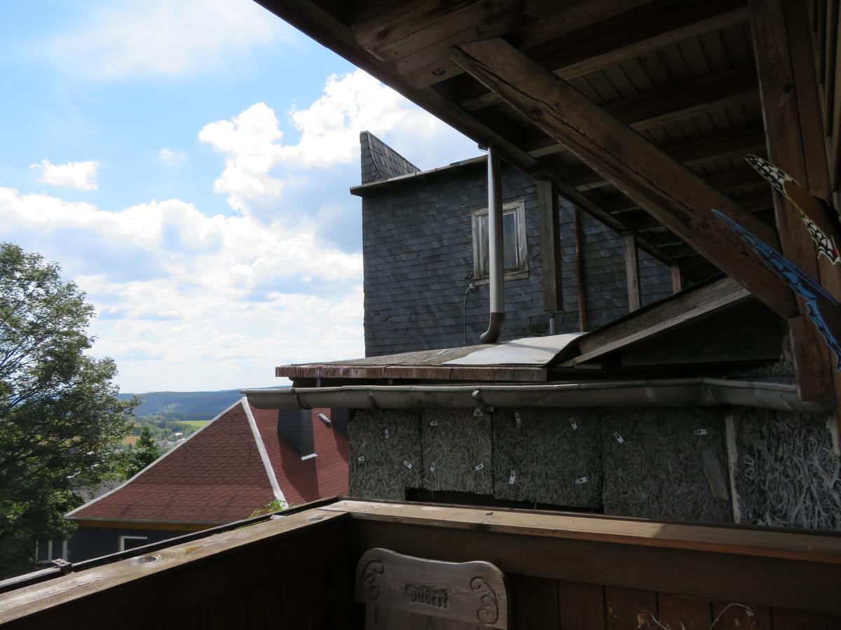 Blick aus Holzbalkon auf diverse schadhafte Anbauten