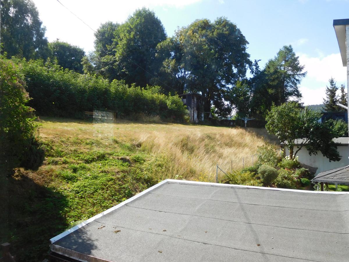 Blick vom Berg hinter dem Haus auf das Haus mit drei Geschossen