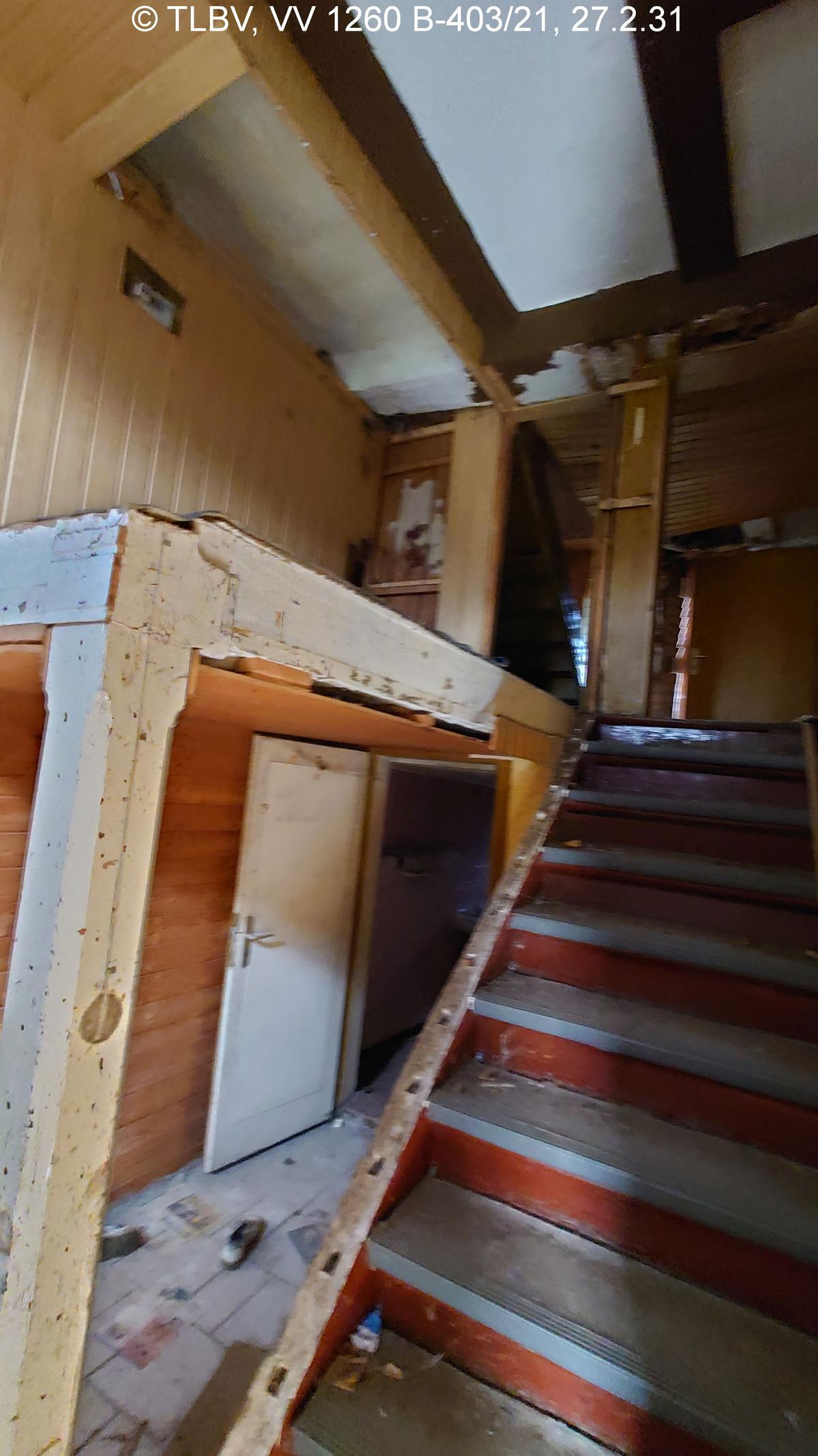 Holztreppe ohne Geländer in verwüstetem Flur