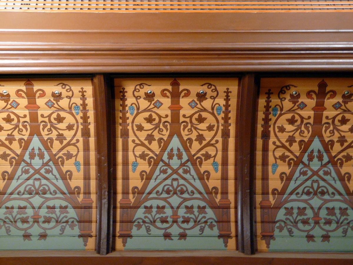 Deckenvouten, drei Stück, nebeneinander, eingefasst von dunkelbraunen Holz, orangener Hintergrund, darauf dunkelbraunen Blumenverzierungen und ein hellblaues Dreieck.