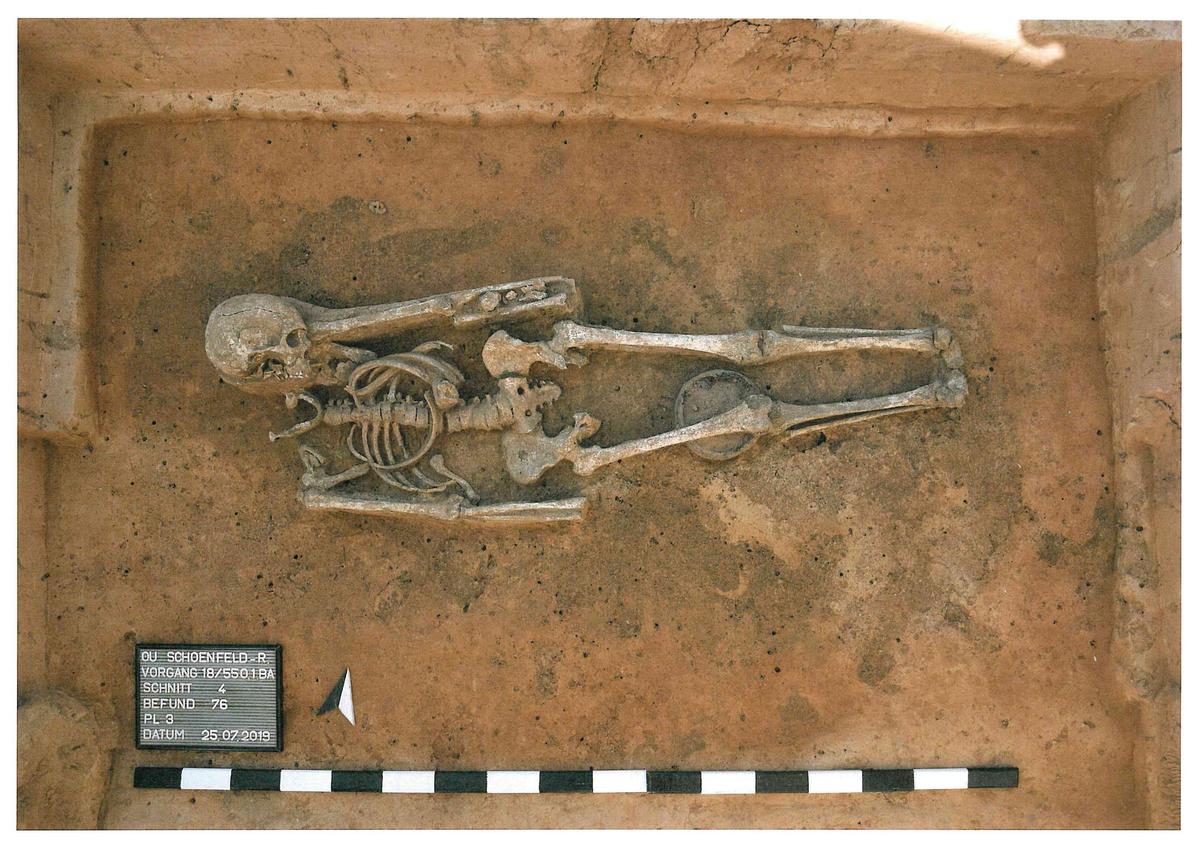 Nur etwa 20 cm unter der heutigen Ackeroberfläche stießen die Ausgräber auf ein bis auf die Hand- und Fußknochen gut erhaltenes Skelett. Dieses datiert ausweislich der 14C-Analyse in die Zeit zwischen 435 und 563 n. Chr. Aufgrund der eher grazilen Knochen und der Zusammensetzung der Beigaben (zwei Gefäße, eine Schnalle - keine Waffen) dürfte hier gegen Ende der Völkerwanderungszeit eine Angehörige des Thüringerreiches bestattet worden sein.