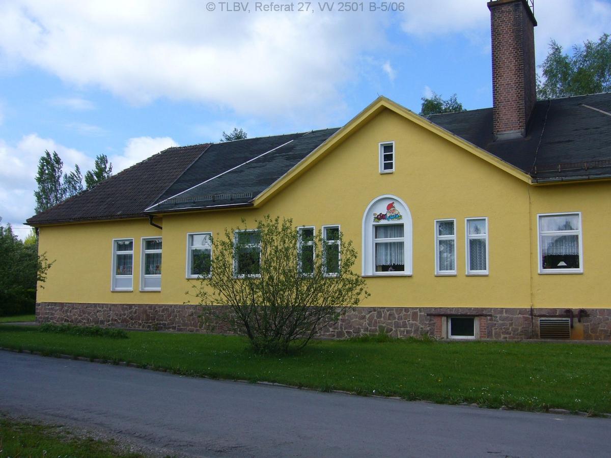 Eingeschossiges gelbes Haus mit Zwerchdachgiebel