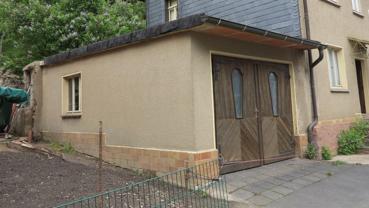 eingeschossiger Garagenanbau; Dach mit Teerpappe gedeckt; an hinterer Seitenfront ein Fenster; Holzdoppeltor direkt zur Straße zu