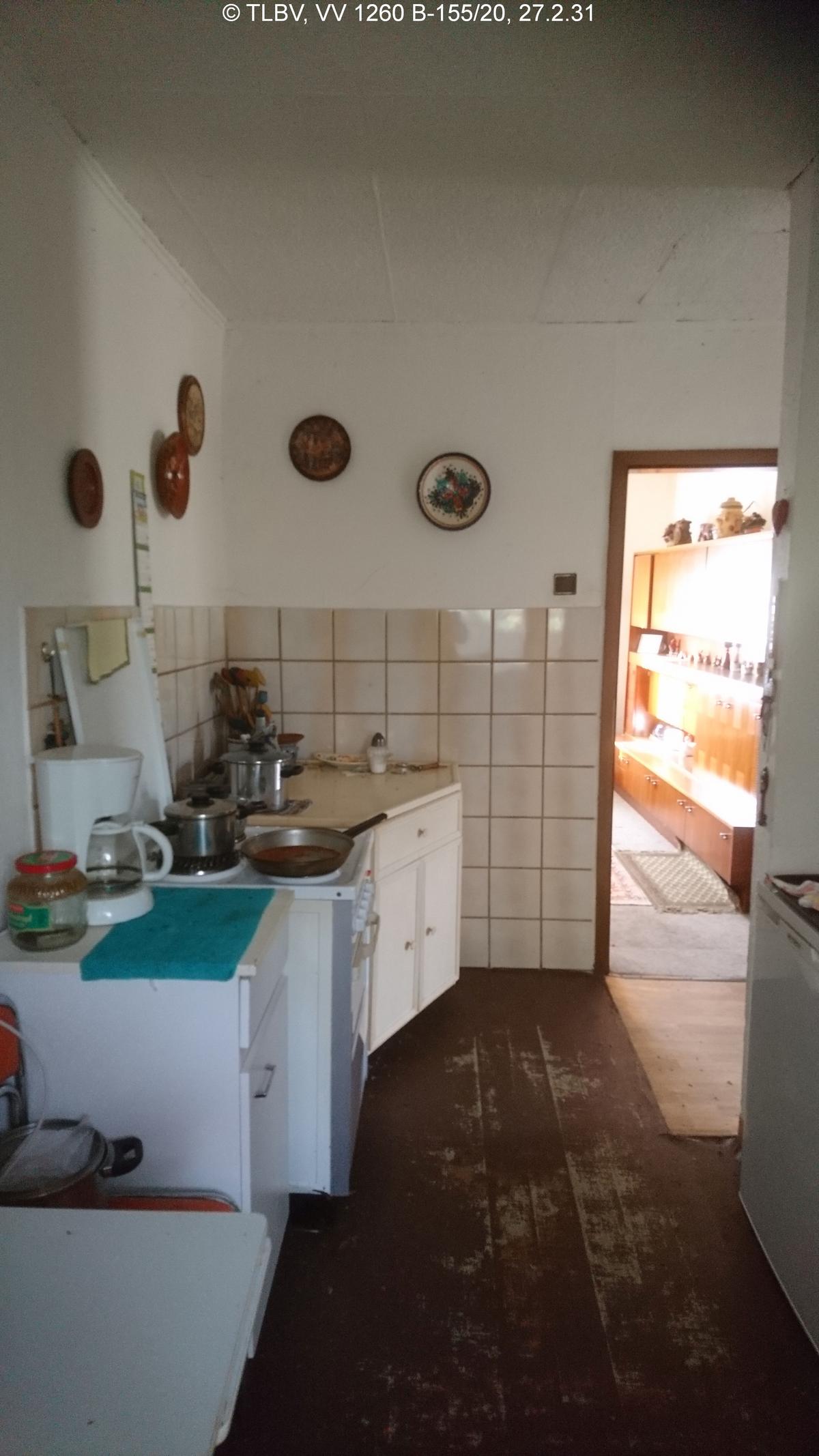 Blick aus Küche Richtung Wohnzimmer, Hoslzdielenfußboden, Teile der Wand sin auf ca. 1,50 m gefliest, unberäumt