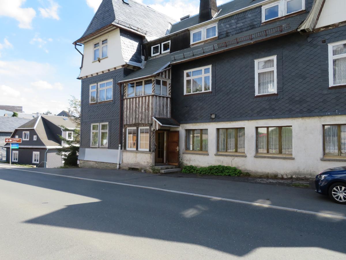 Wohn- und Geschäftshaus, 2 geschossig an Kreuzung, Fassade mit Schindeln, Dach mit Gauben