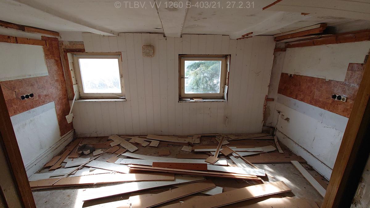 kleines und niedriges Zimmer mit zwei Fenstern, Steckdosen entnommen, Wand- und Deckenverkleidung großflächig abgefallen