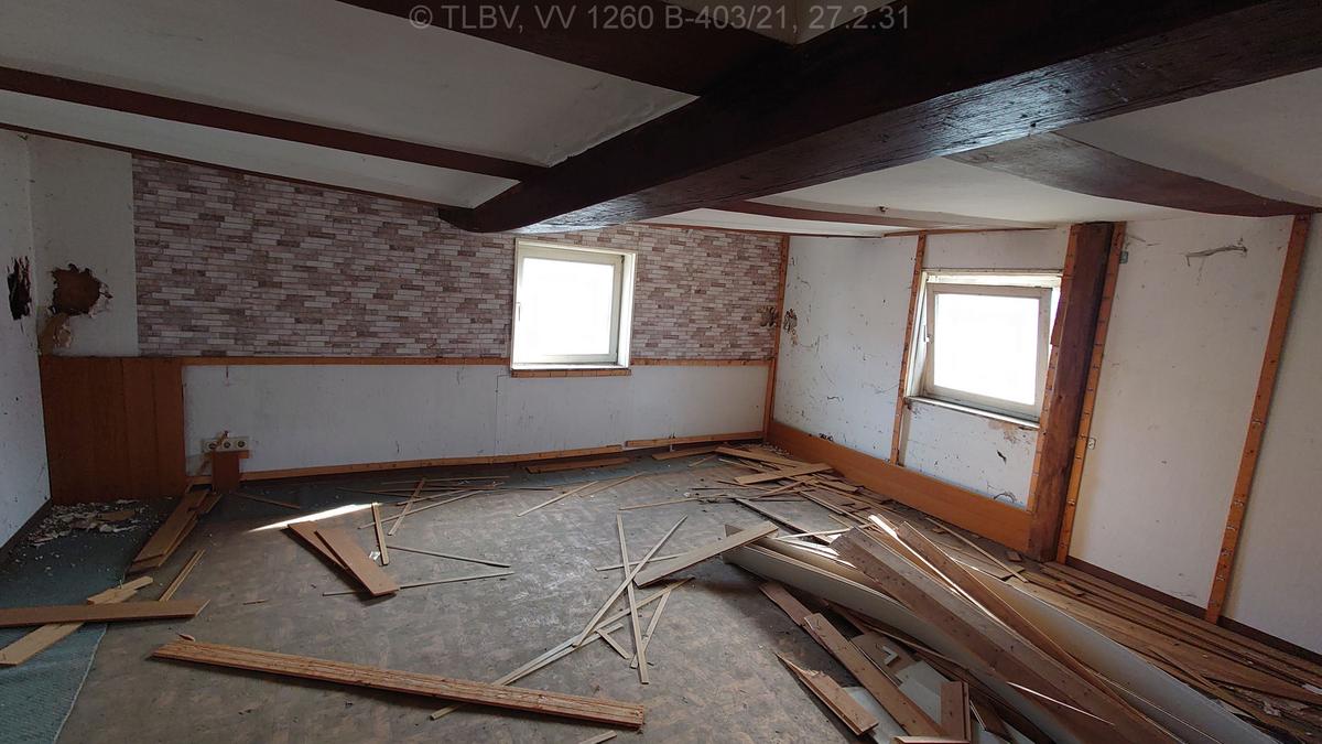 Zimmer mit scheinbar niedriger Deckenhöhe, zwei Fenster, Deckenbalken scheint durchzuhängen
