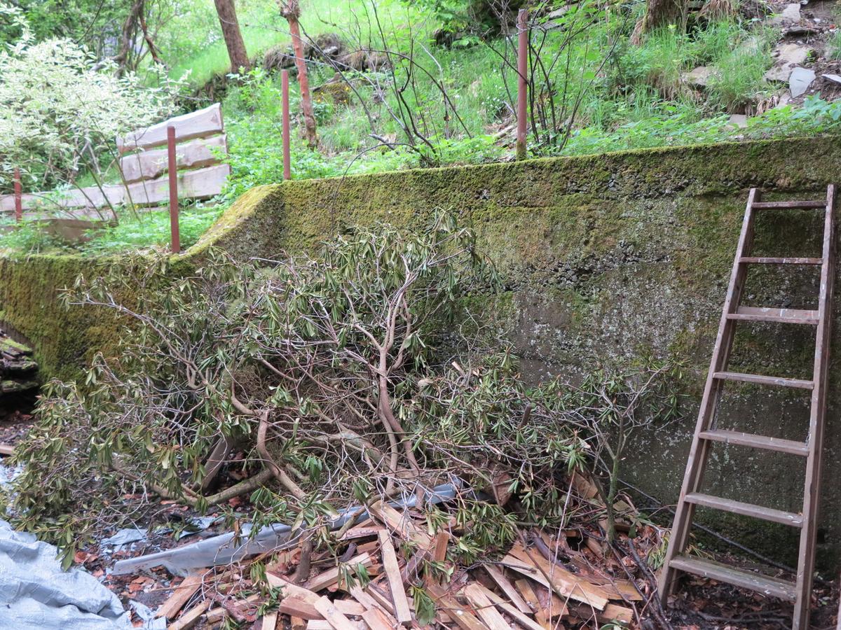 ca. 2 m hohe Stützmauer hinter dem Haus