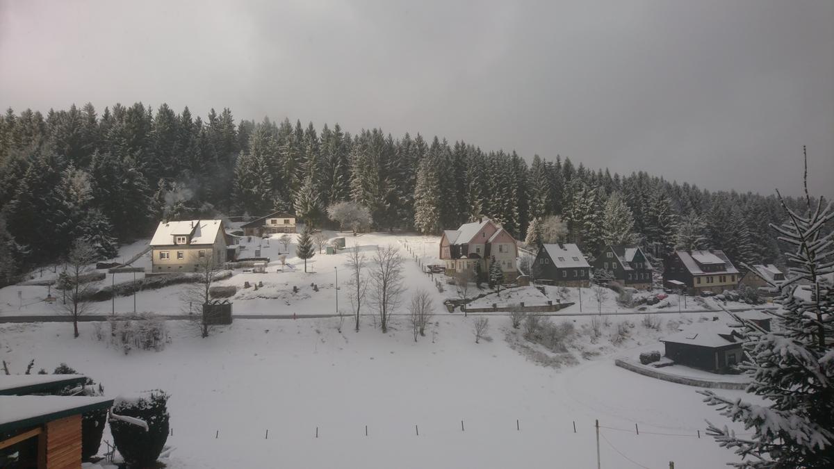 Blick aus oberer Etage über Tal auf die andere, bebaute Seite des Hanges mit Wald; idyllisch
