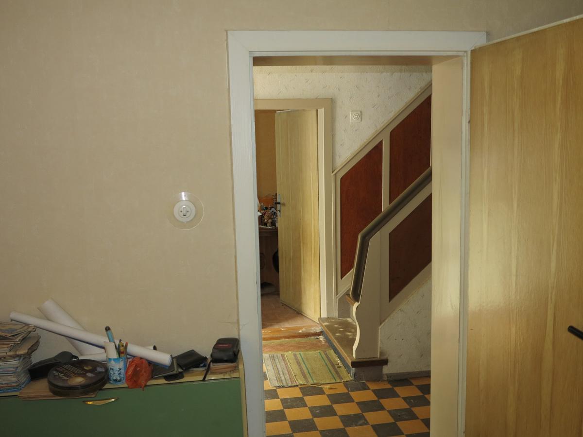 Blick von einem Zimmer über den Flur im EG in ein gegenüberliegendes Zimmer. alles unberäumt, tlw. vermüllt und verschlissen
