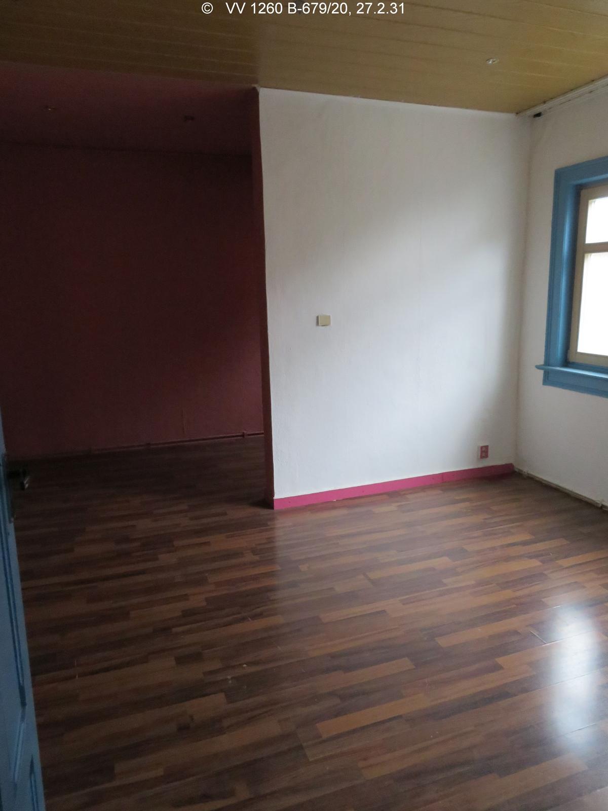 Zimmer mit Laminat und einem Fenster