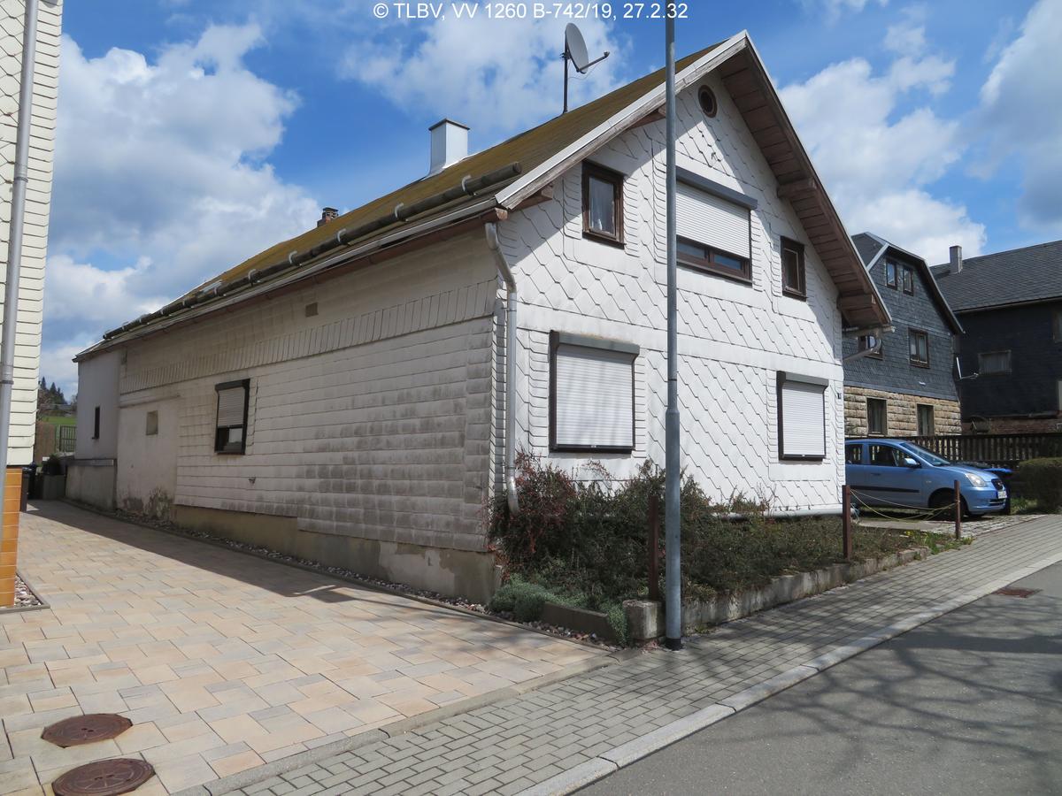 giebelständiges Wohnhaus mit flacherem Satteldach; Fassadenschindeln hell