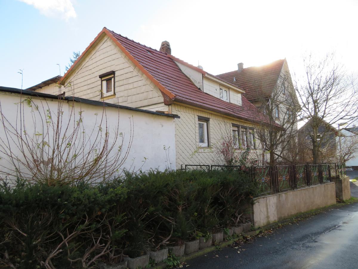 Südansicht Wohnhaus und Garage mit verwildertem Vorgarten