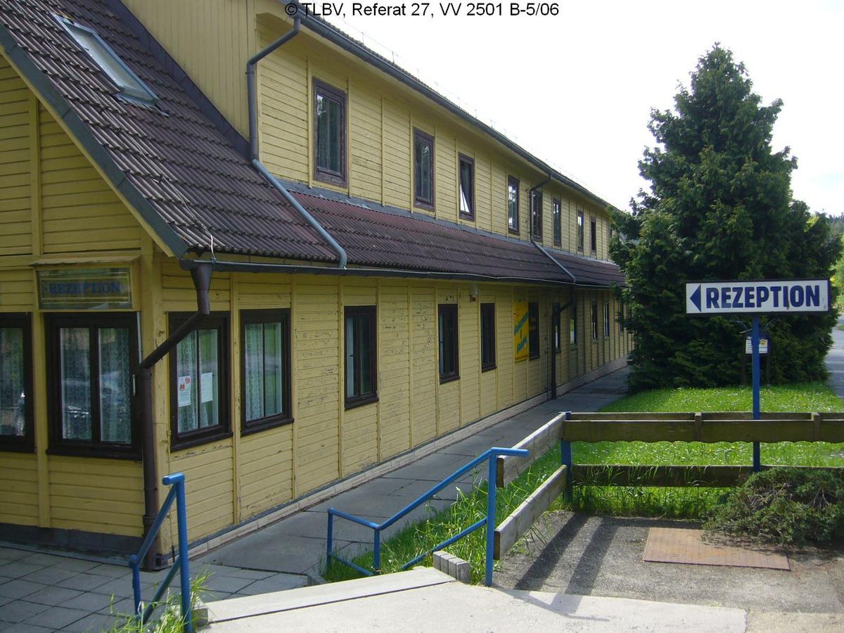 eingeschossiges, langgestrecktes gelbes Haus mit über die gesamt Dachlänge gestreckter Gaube