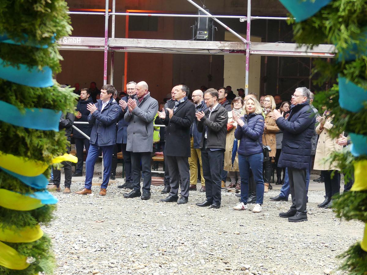 Zuschauer beim Richtfest betrachten die Richtkrone