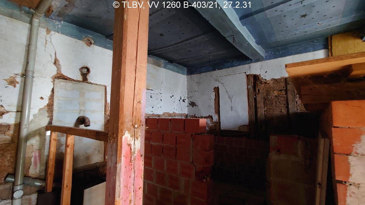 Zimmer mit innenliegender halbhoher Backsteinmauer, Holzstütze, Decke bemalt
