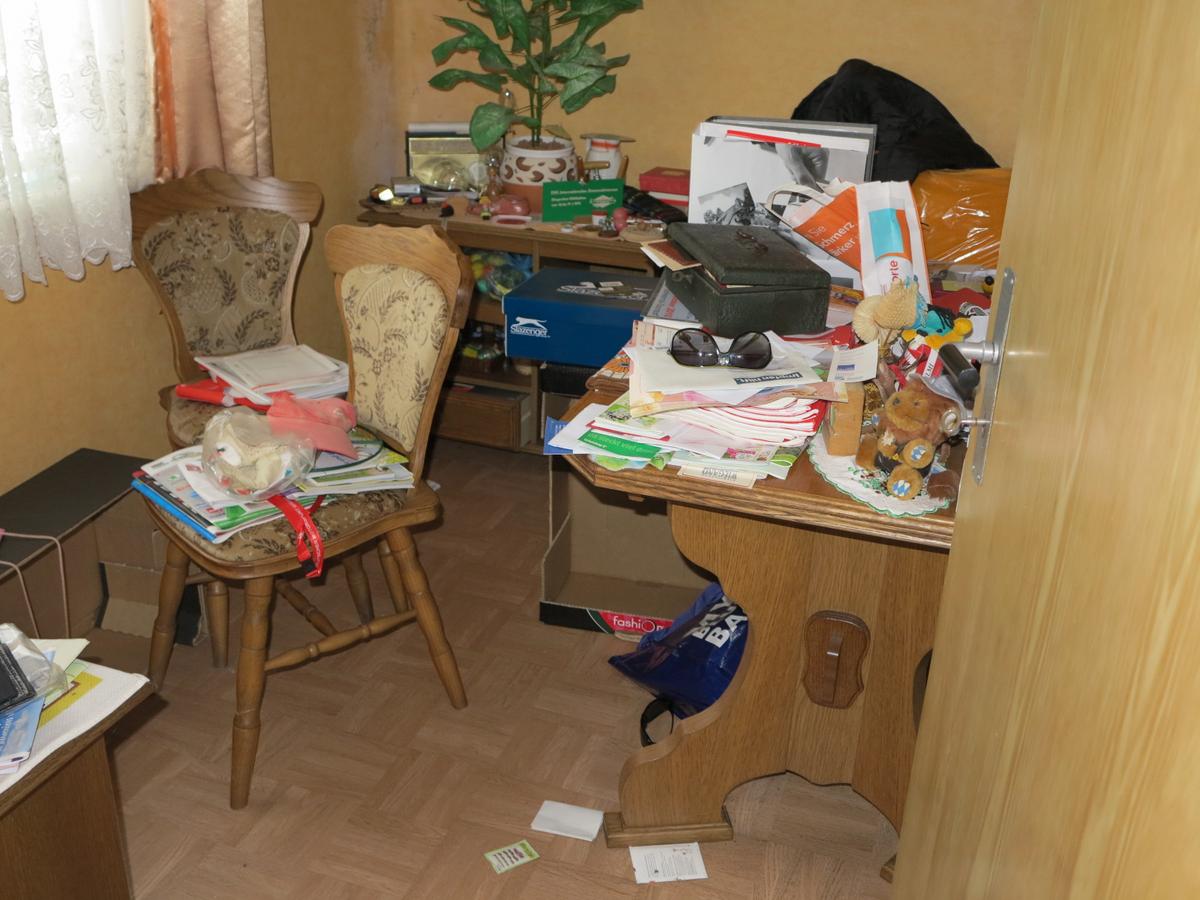 kleines Arbeitszimmer mit Fenster, scheinbar ohne Heizung; unberäumt, tlw. vermüllt