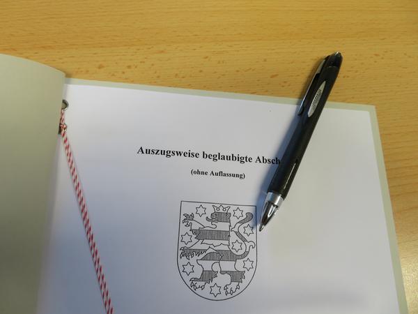 Deckblatt eines Grundstücksvertrages und Stift